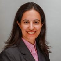 A woman in a business suit smiling.