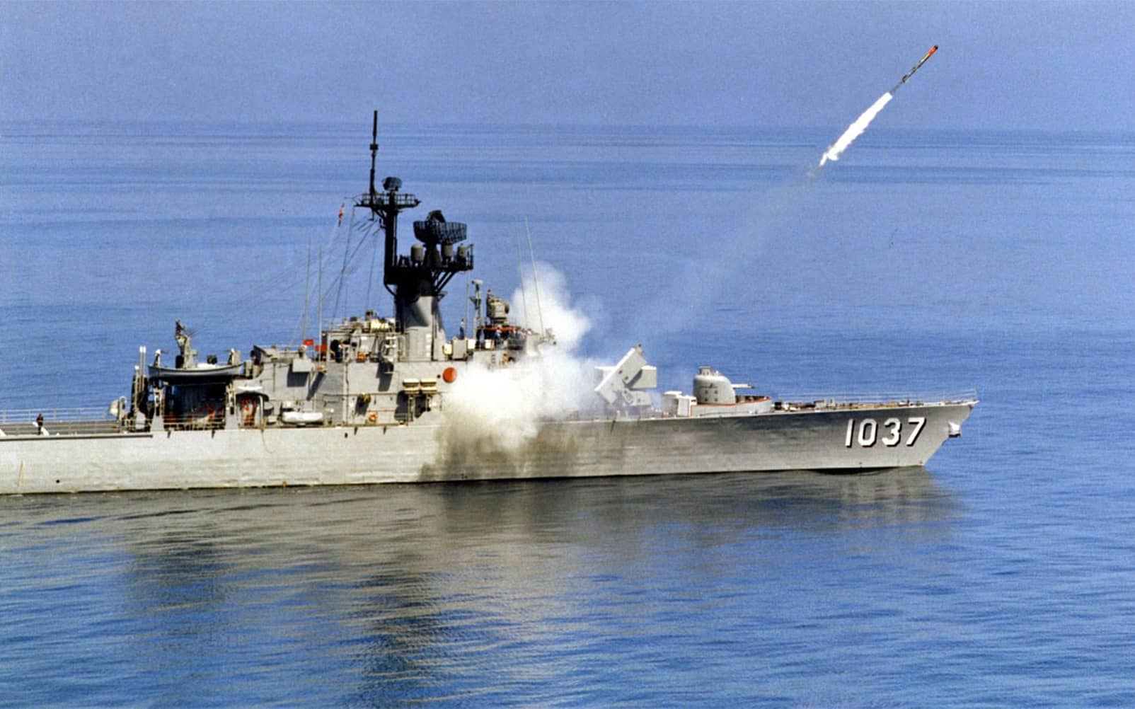 A navy ship firing a missile in the ocean in color.