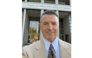 Man in front of courthouse building entrance.