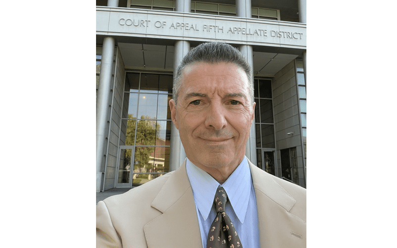 Man in front of courthouse building entrance.